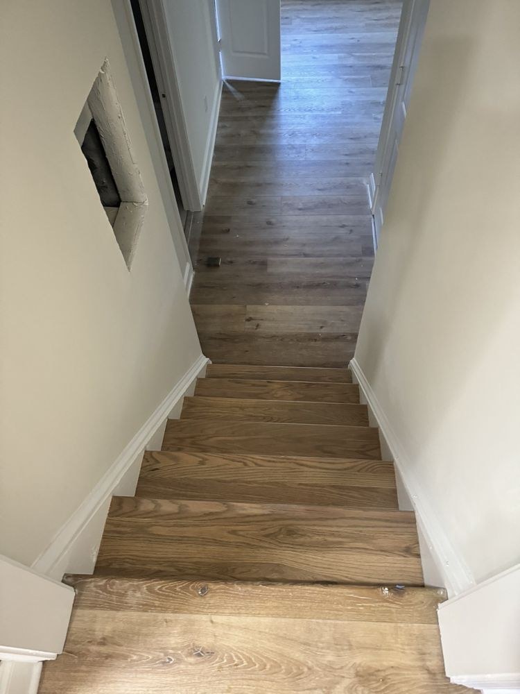 Hardwood stair treads leading up to a refinished upstairs hallway floor